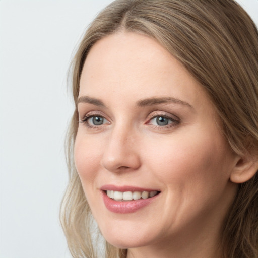 Joyful white young-adult female with long  brown hair and blue eyes