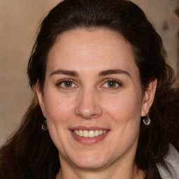 Joyful white adult female with long  brown hair and brown eyes