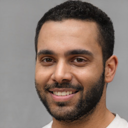 Joyful black young-adult male with short  black hair and brown eyes