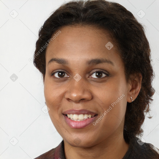 Joyful black young-adult female with long  brown hair and brown eyes