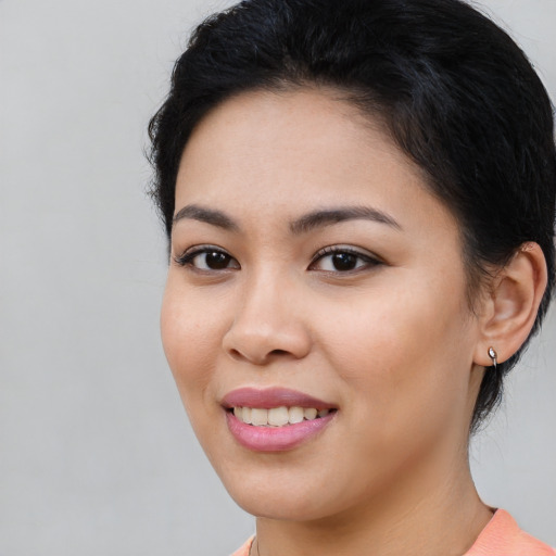 Joyful latino young-adult female with medium  brown hair and brown eyes