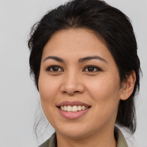 Joyful latino young-adult female with medium  brown hair and brown eyes