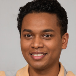 Joyful black young-adult male with short  brown hair and brown eyes