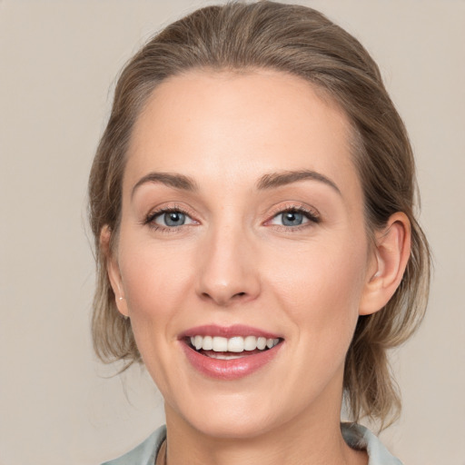 Joyful white young-adult female with medium  brown hair and grey eyes