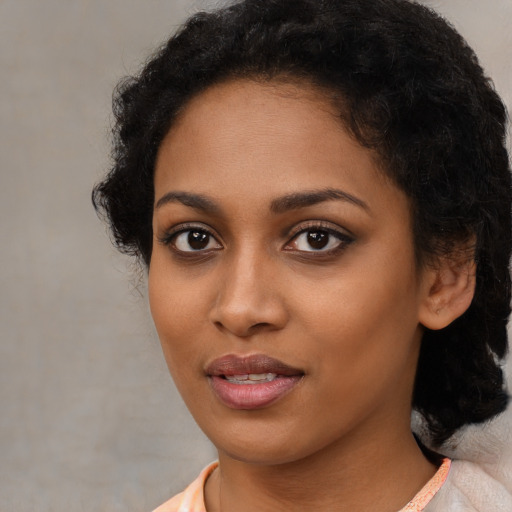 Joyful black young-adult female with medium  black hair and brown eyes