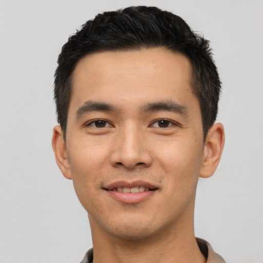 Joyful asian young-adult male with short  black hair and brown eyes