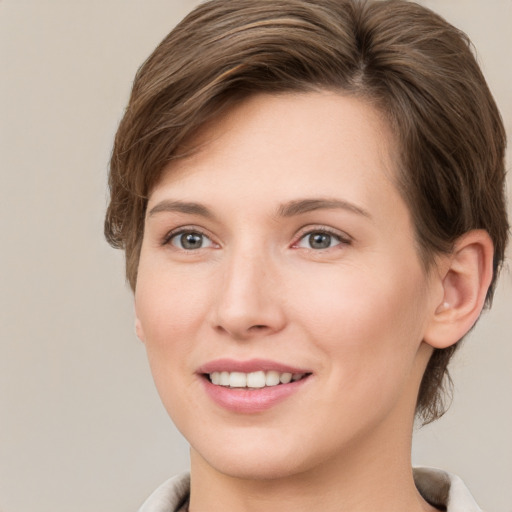 Joyful white young-adult female with short  brown hair and grey eyes