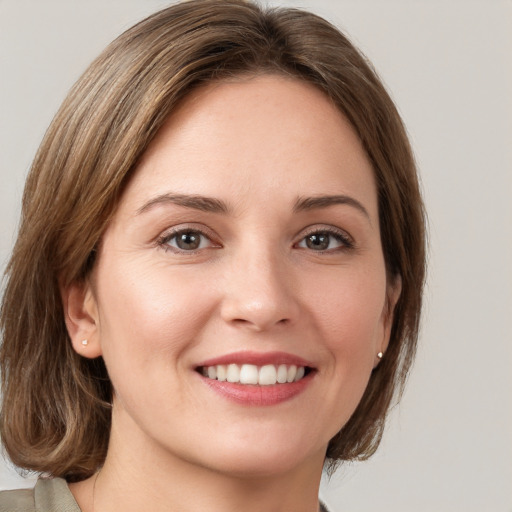 Joyful white young-adult female with medium  brown hair and green eyes