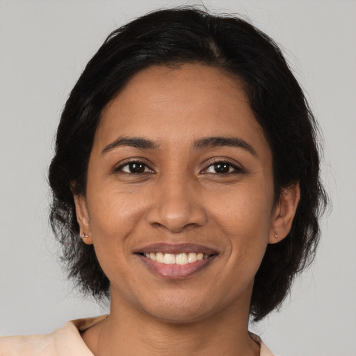 Joyful latino adult female with medium  brown hair and brown eyes