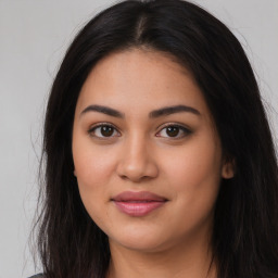 Joyful latino young-adult female with long  brown hair and brown eyes