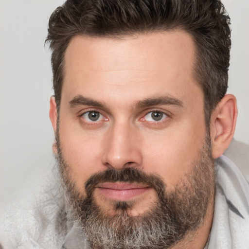 Joyful white adult male with short  brown hair and brown eyes