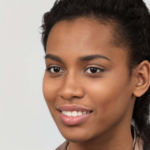 Joyful black young-adult female with long  brown hair and brown eyes