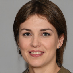 Joyful white young-adult female with medium  brown hair and grey eyes