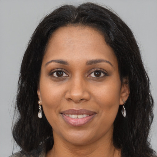 Joyful black adult female with long  brown hair and brown eyes