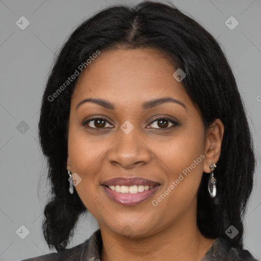 Joyful black young-adult female with long  black hair and brown eyes