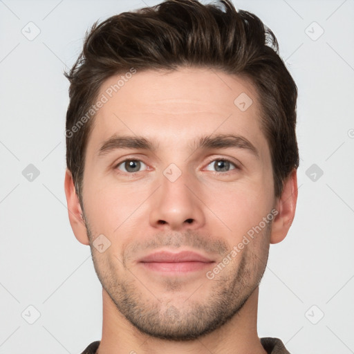 Joyful white young-adult male with short  brown hair and grey eyes