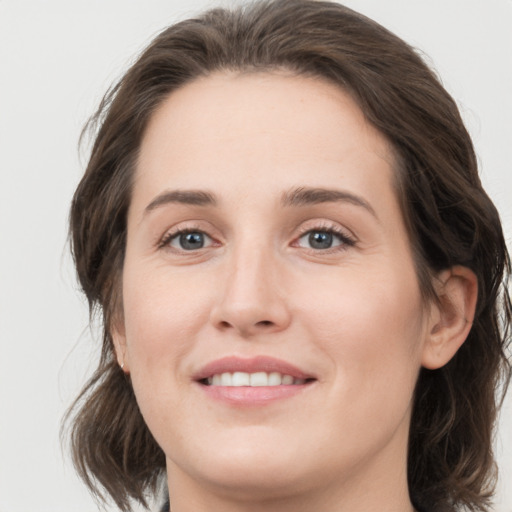 Joyful white young-adult female with medium  brown hair and grey eyes