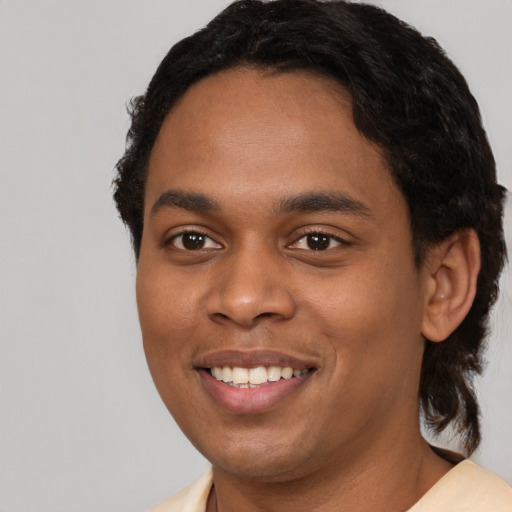 Joyful black young-adult male with short  black hair and brown eyes