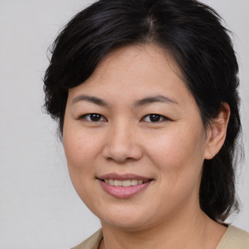 Joyful asian adult female with medium  brown hair and brown eyes