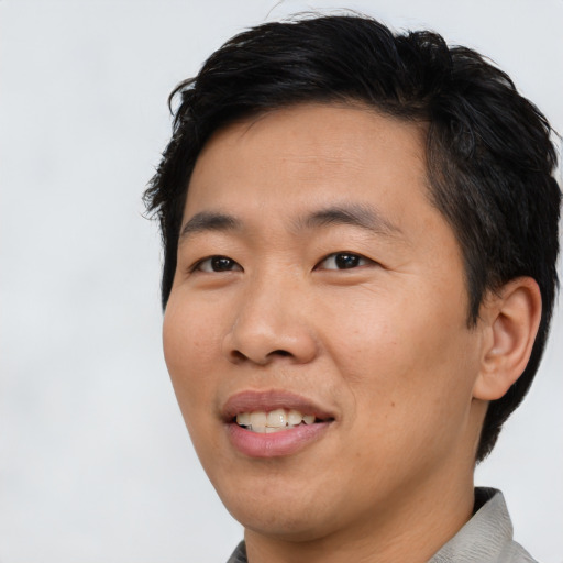 Joyful asian adult male with short  black hair and brown eyes