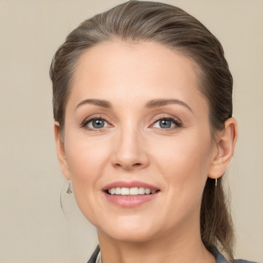 Joyful white young-adult female with medium  brown hair and grey eyes