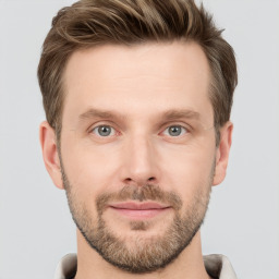 Joyful white young-adult male with short  brown hair and grey eyes