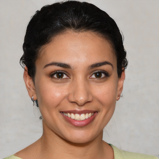 Joyful latino young-adult female with short  brown hair and brown eyes