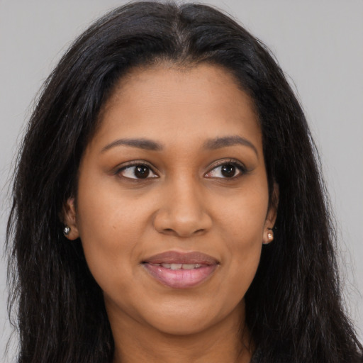 Joyful black young-adult female with long  brown hair and brown eyes