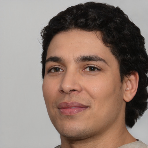 Joyful white young-adult male with short  black hair and brown eyes