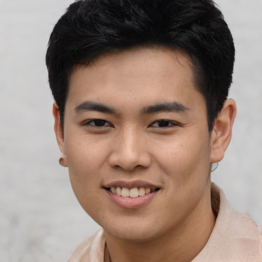 Joyful asian young-adult male with short  brown hair and brown eyes