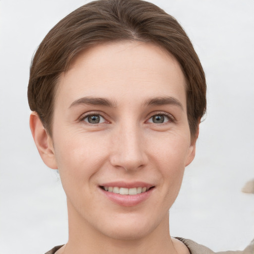 Joyful white young-adult female with short  brown hair and grey eyes