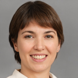 Joyful white young-adult female with medium  brown hair and grey eyes