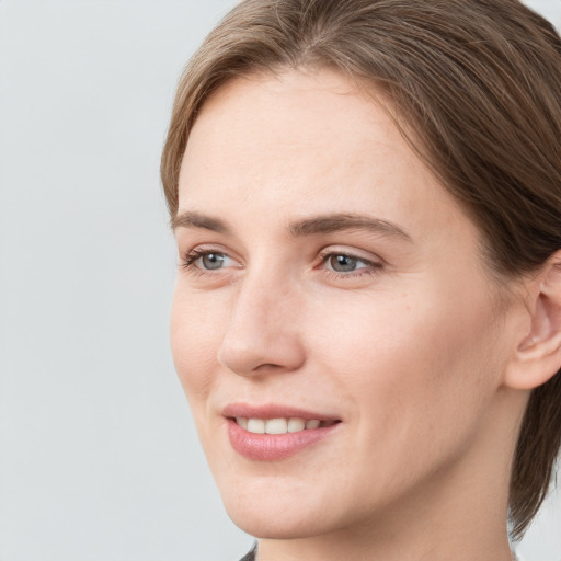 Joyful white young-adult female with medium  brown hair and grey eyes