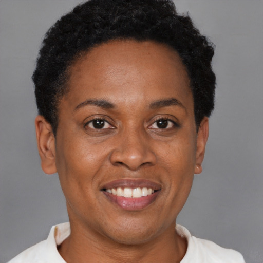 Joyful black adult female with short  black hair and brown eyes