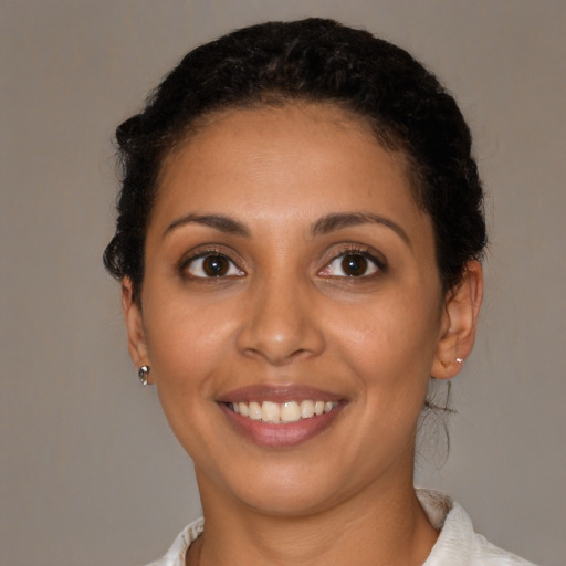 Joyful latino young-adult female with short  brown hair and brown eyes