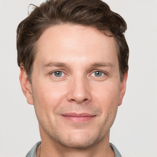 Joyful white adult male with short  brown hair and grey eyes