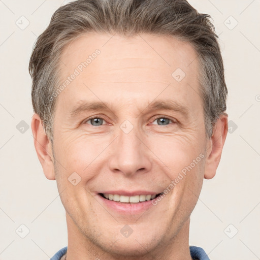 Joyful white adult male with short  brown hair and grey eyes