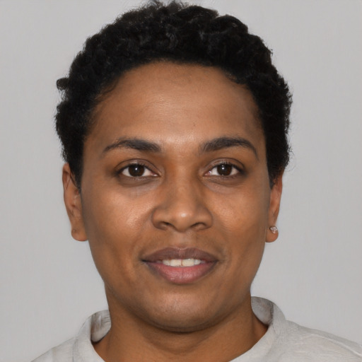 Joyful black young-adult female with short  black hair and brown eyes