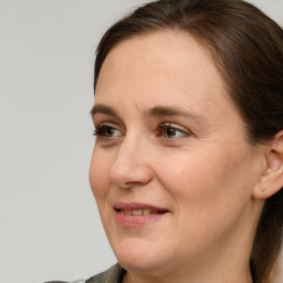 Joyful white adult female with long  brown hair and grey eyes