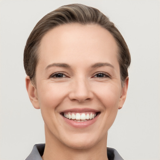 Joyful white young-adult female with short  brown hair and grey eyes