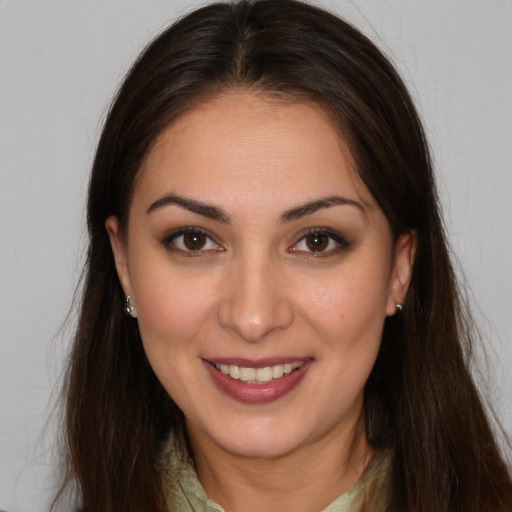 Joyful white young-adult female with long  brown hair and brown eyes