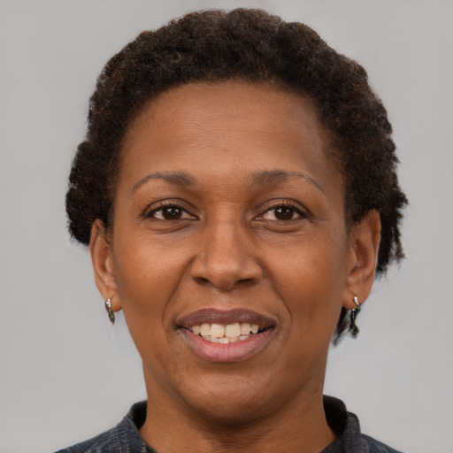 Joyful black adult female with short  brown hair and brown eyes