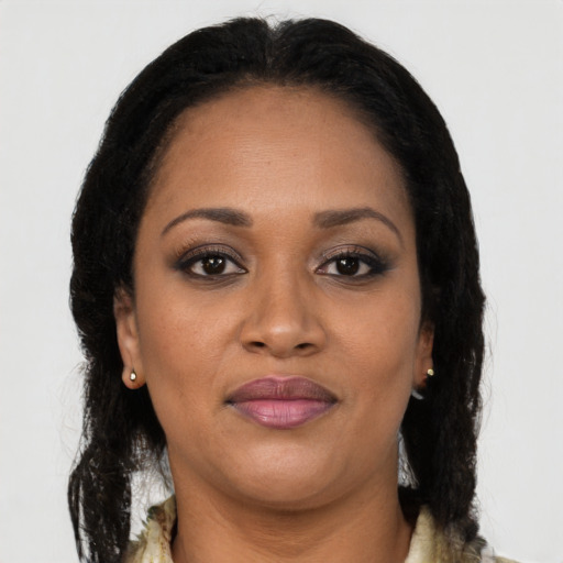 Joyful black adult female with long  brown hair and brown eyes