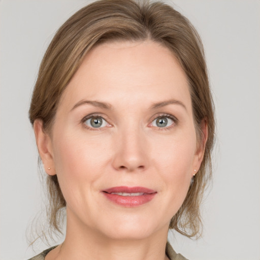 Joyful white adult female with medium  brown hair and grey eyes