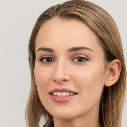 Joyful white young-adult female with long  brown hair and brown eyes