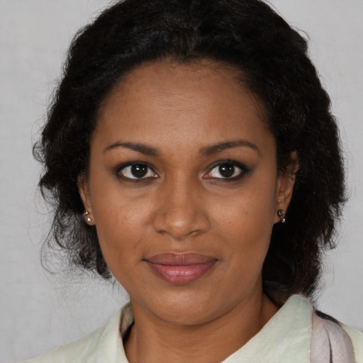 Joyful black adult female with medium  brown hair and brown eyes
