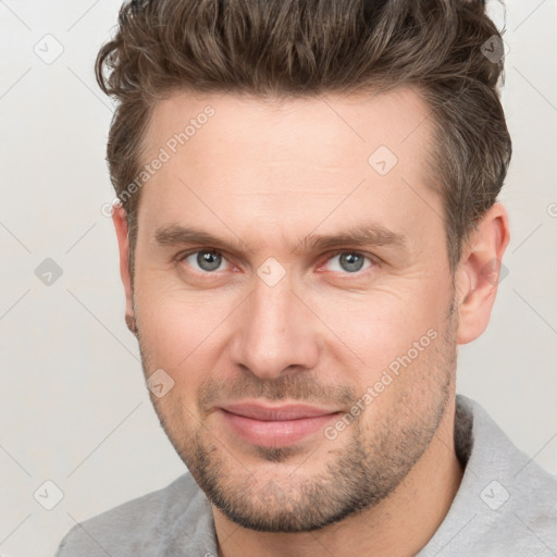 Joyful white adult male with short  brown hair and grey eyes