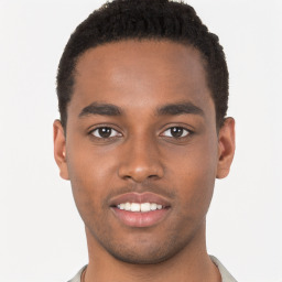 Joyful black young-adult male with short  brown hair and brown eyes