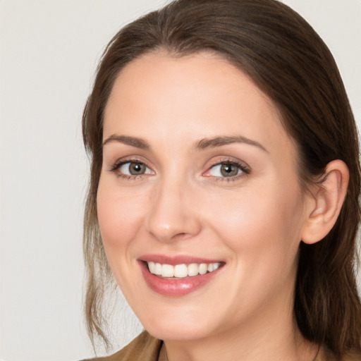 Joyful white young-adult female with long  brown hair and brown eyes