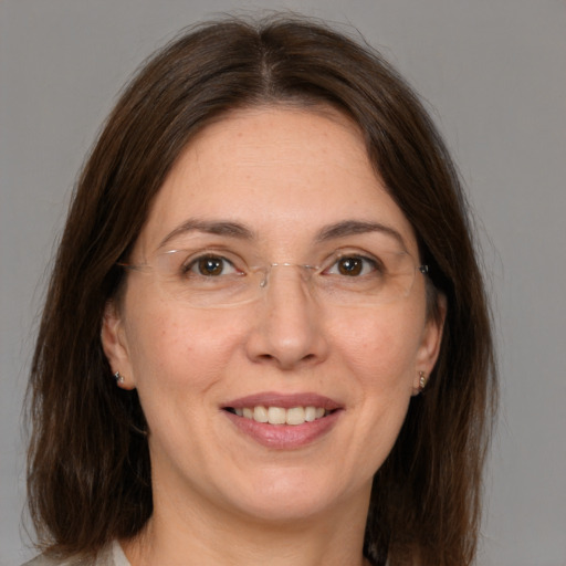 Joyful white adult female with medium  brown hair and grey eyes